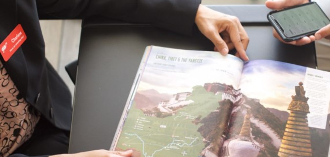 AAA Travel Agent shows a AAA vacation guide to China to a Member