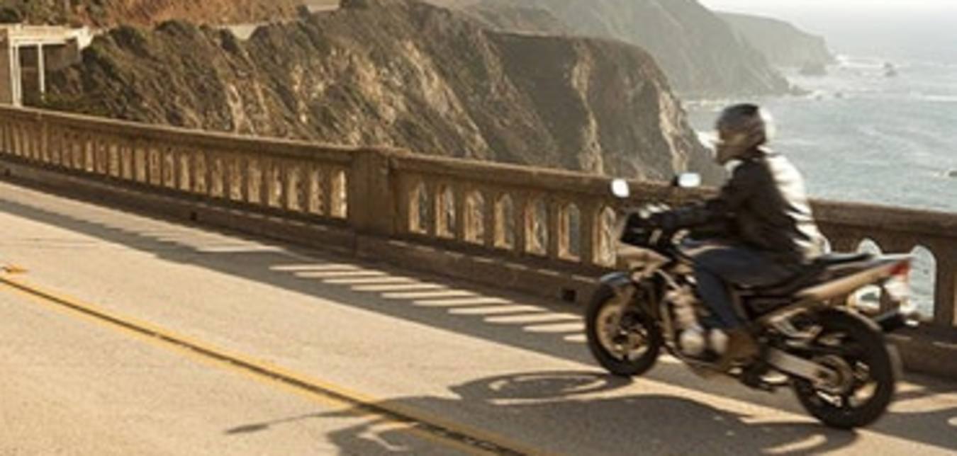a motorcyclist with AAA specialty insurance drives down highway 1 in Big Sur on the California coast