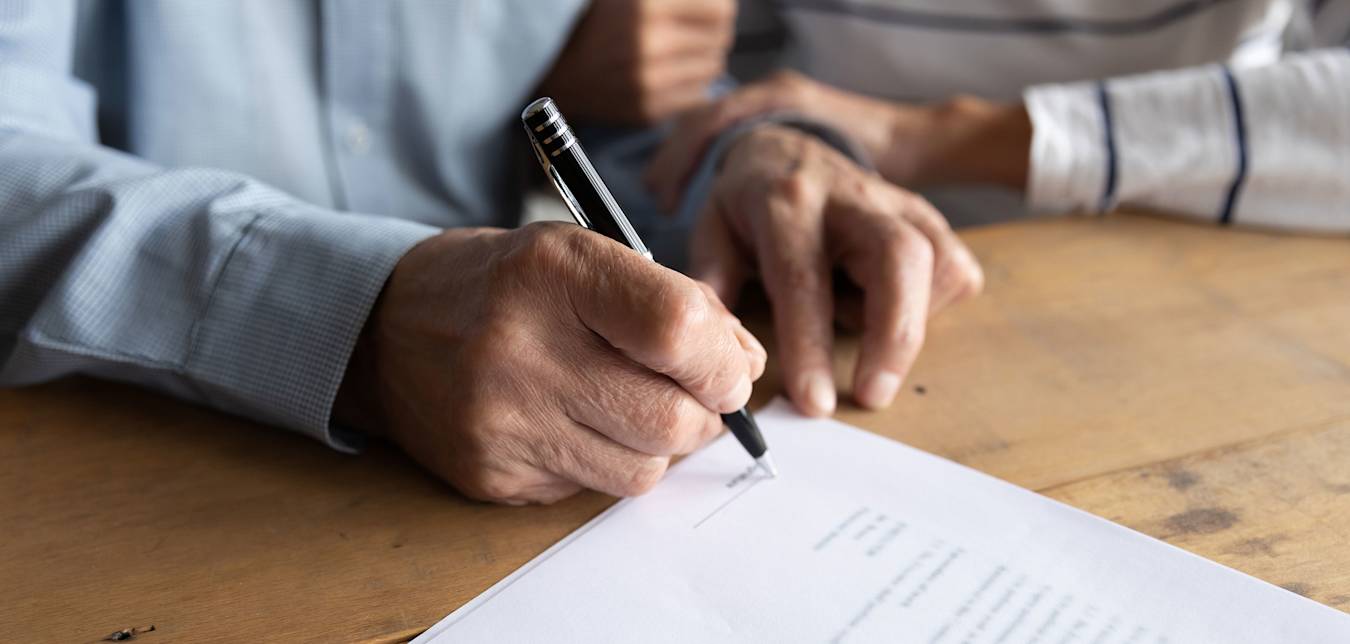 A couple sign a document with a notary.