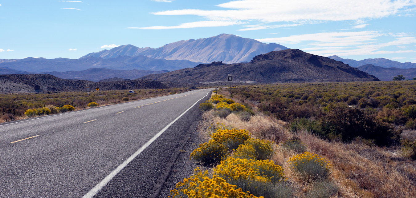 Empty Highway 50 stretches into the Nevada desert on a party cloudy day.