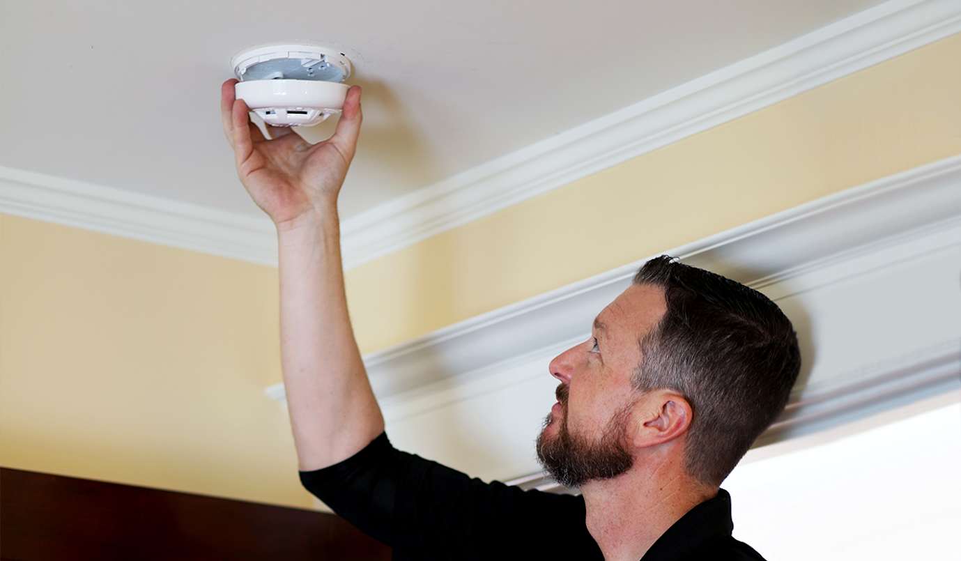 Man installing smoke alarm