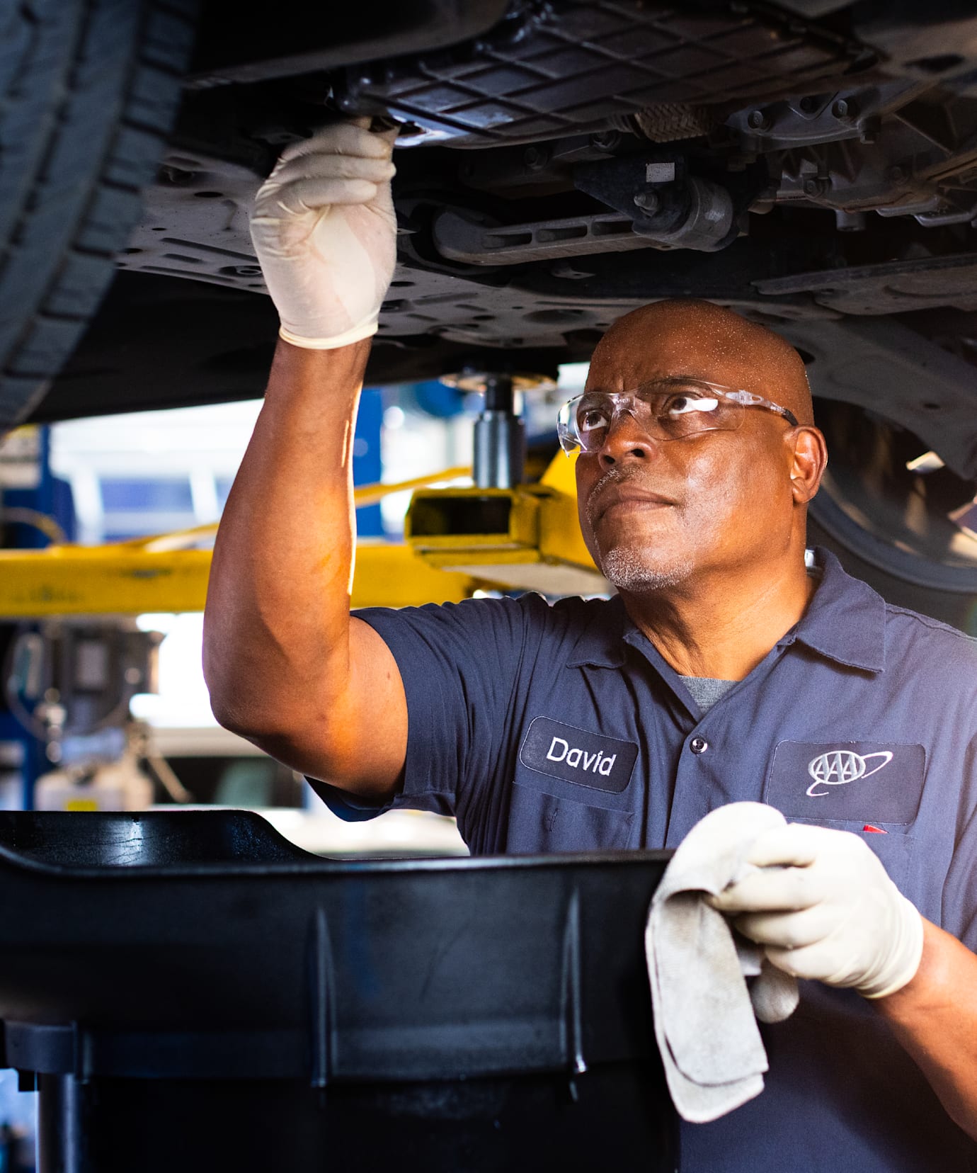 AAA auto repair center ASE-certified technician does an oil change