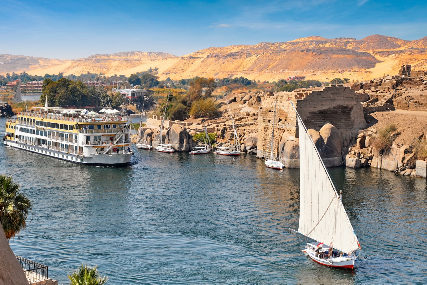river cruise ship and sailboat in water