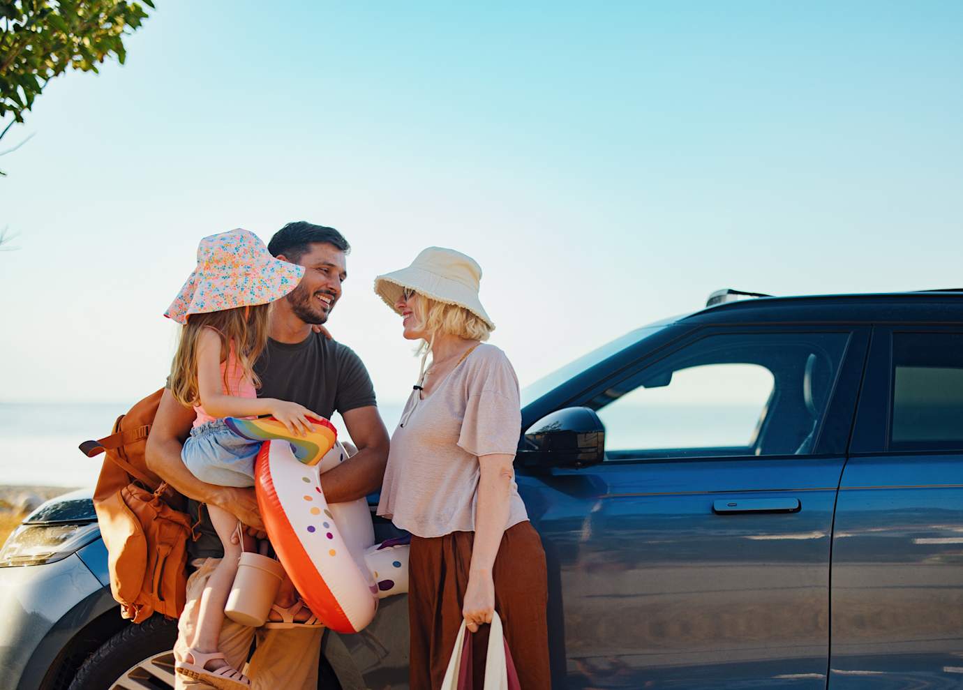 man and woman standing outside car with child
