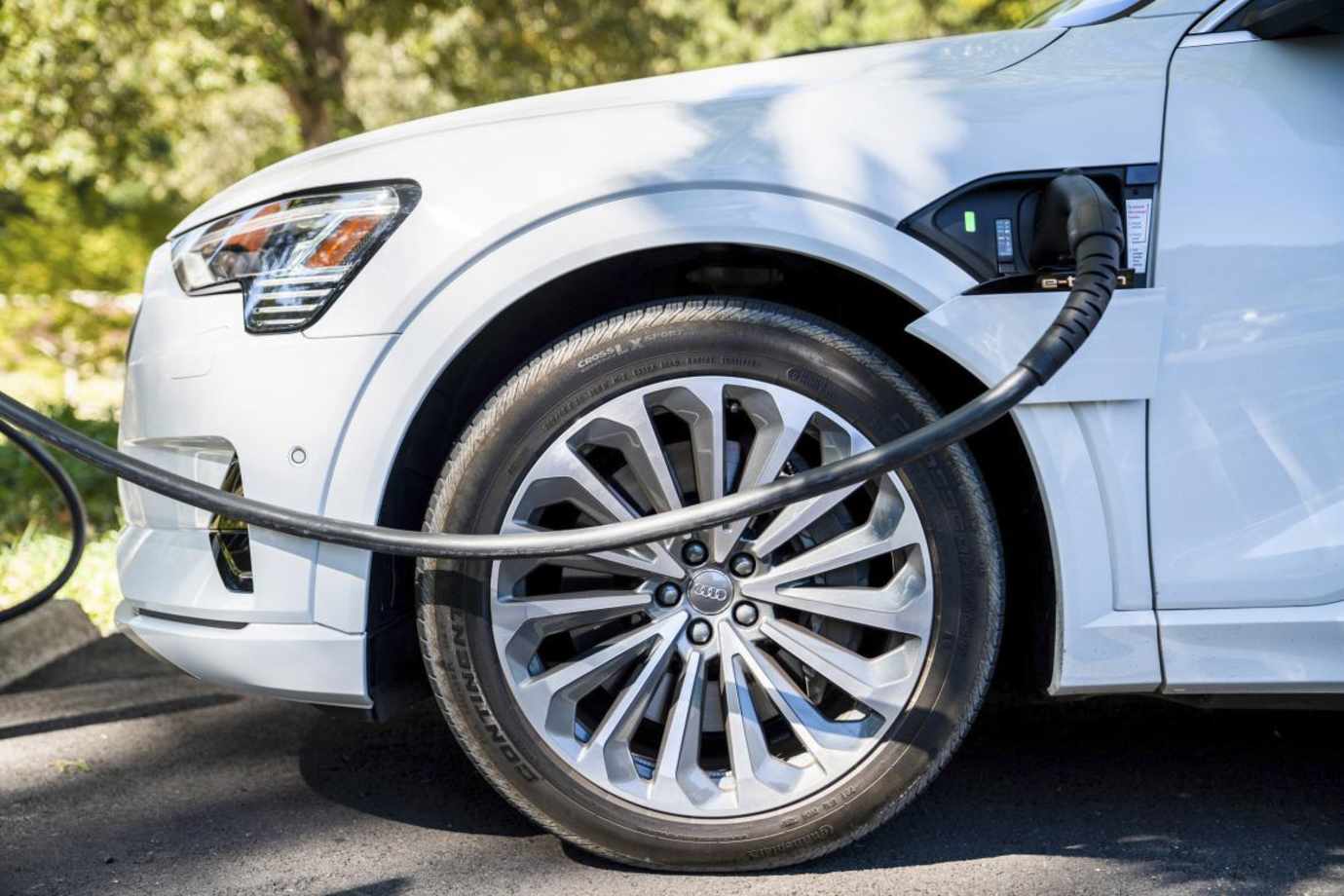 An Audi E-tron plugged into an EV charger.