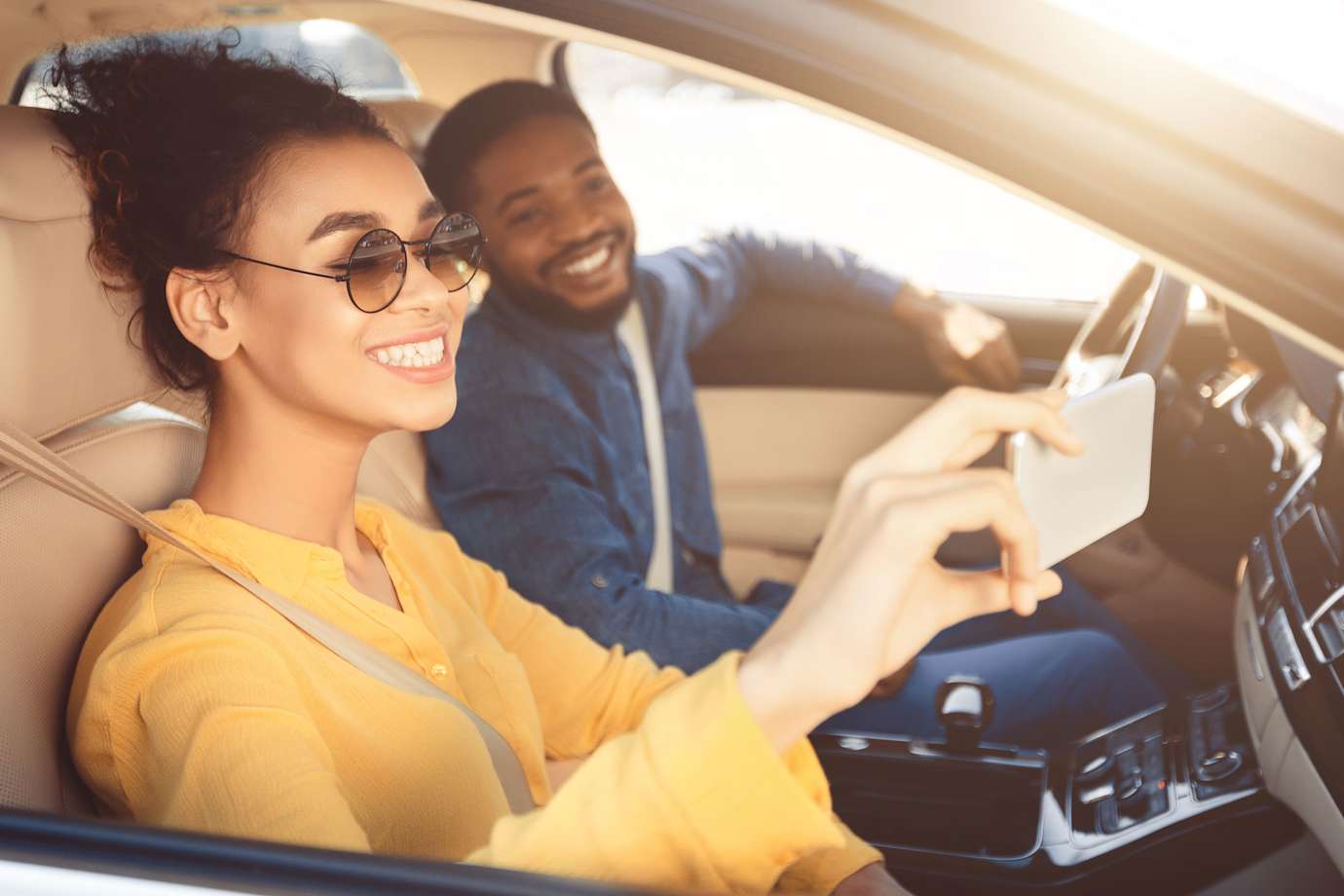 a couple taking a selfie in their car protected by aaa car insurance