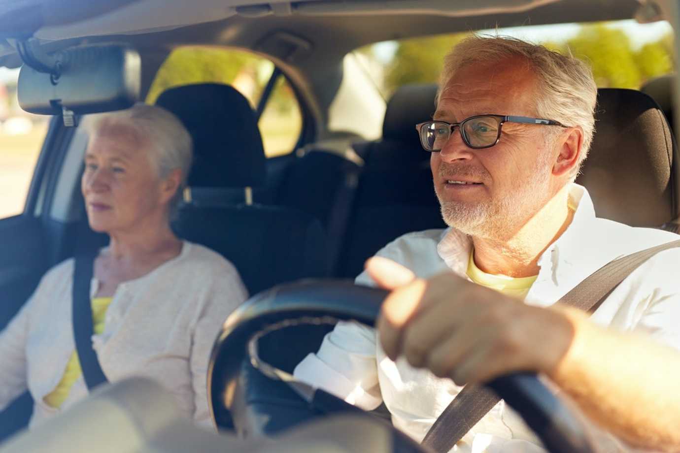 An elderly couple behind the wheel.