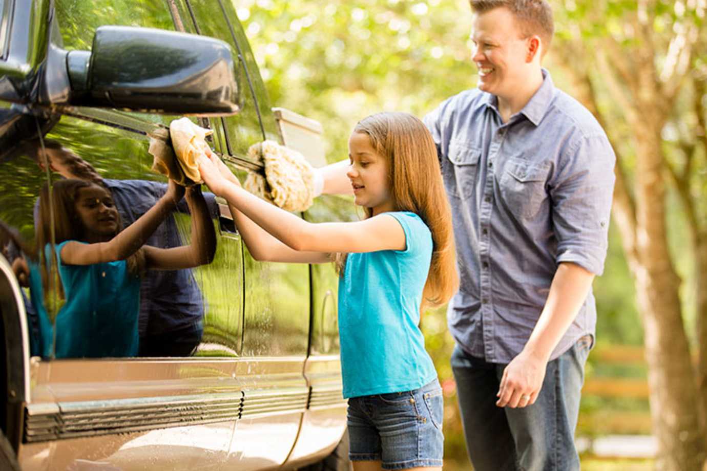 Father and daughter washing a pickup truck insured by AAA Auto Insurance
