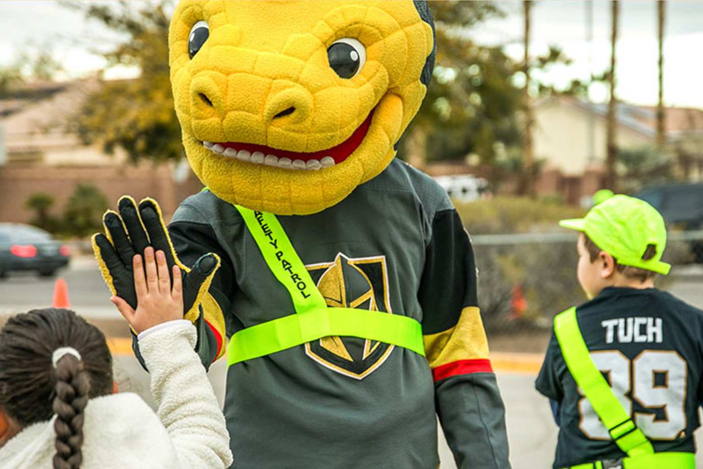 Vegas Golden Knights mascot, Chance the Gila monster, high fives kids while helping during AAA School Safety Patrol event