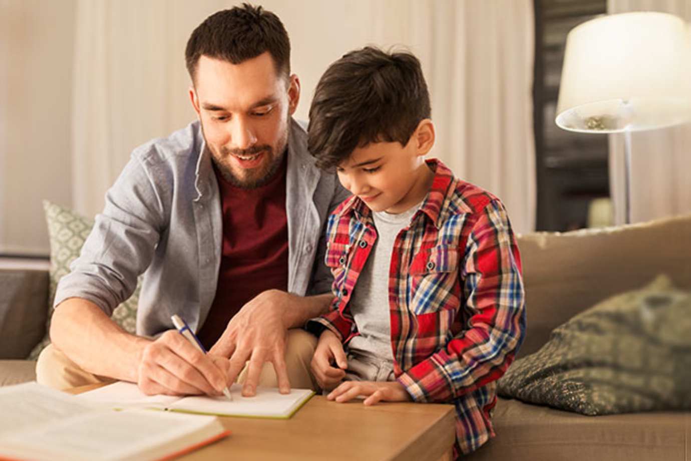 A man helps an elementary student with homework