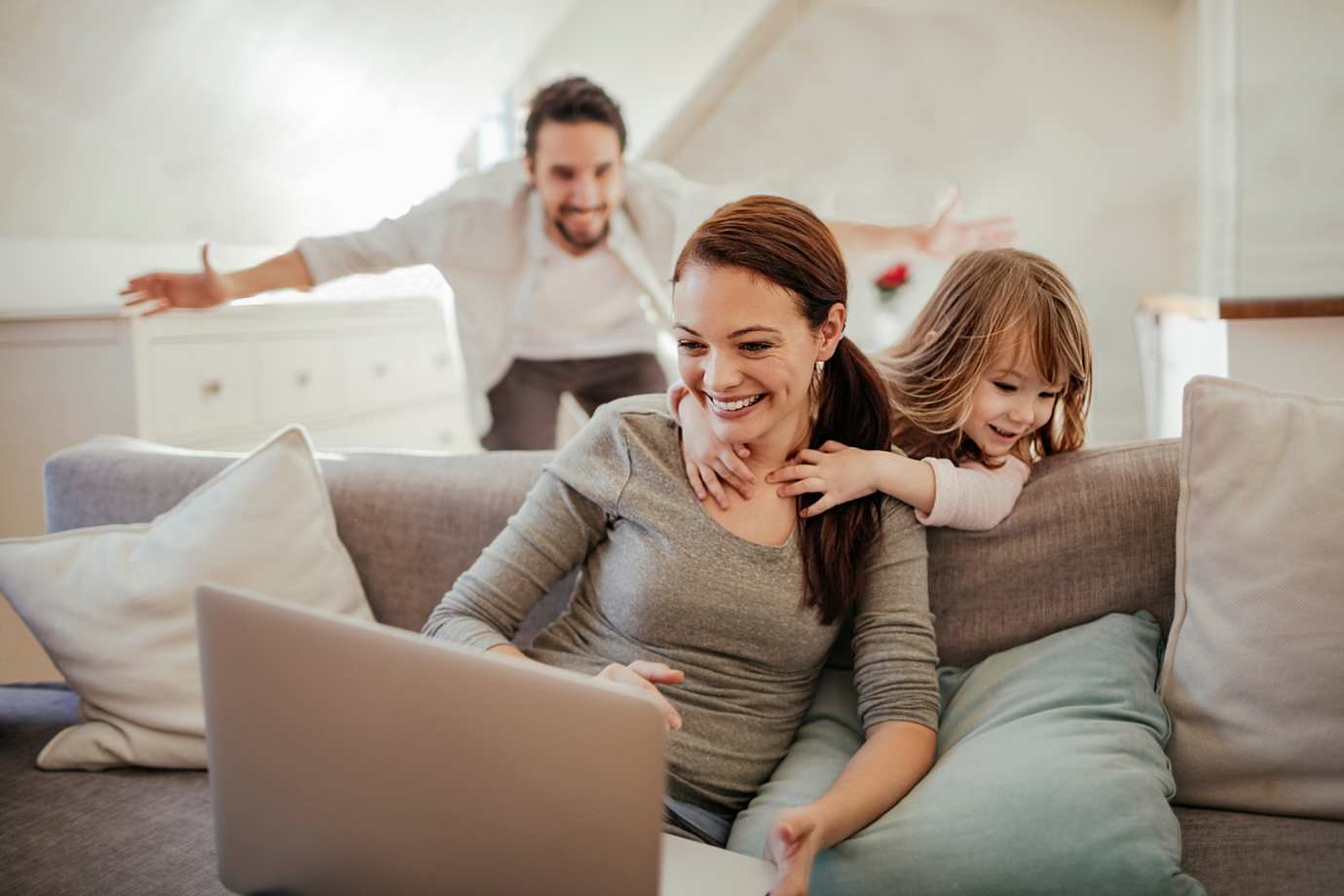 a family playing on the couch at their house protected by AAA home insurance