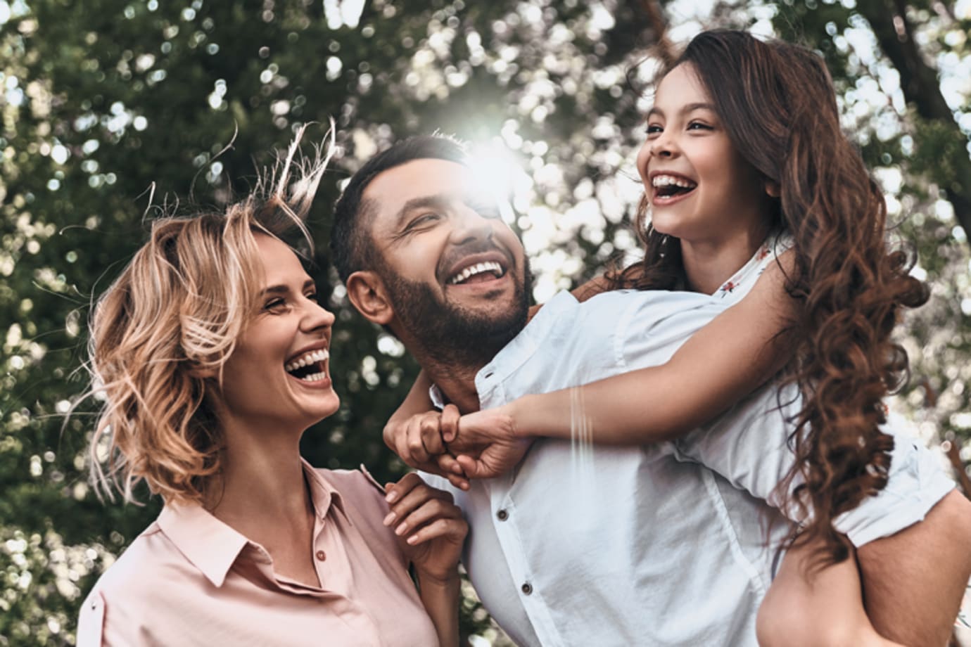 Family with dad carrying the daughter and mom is smiling