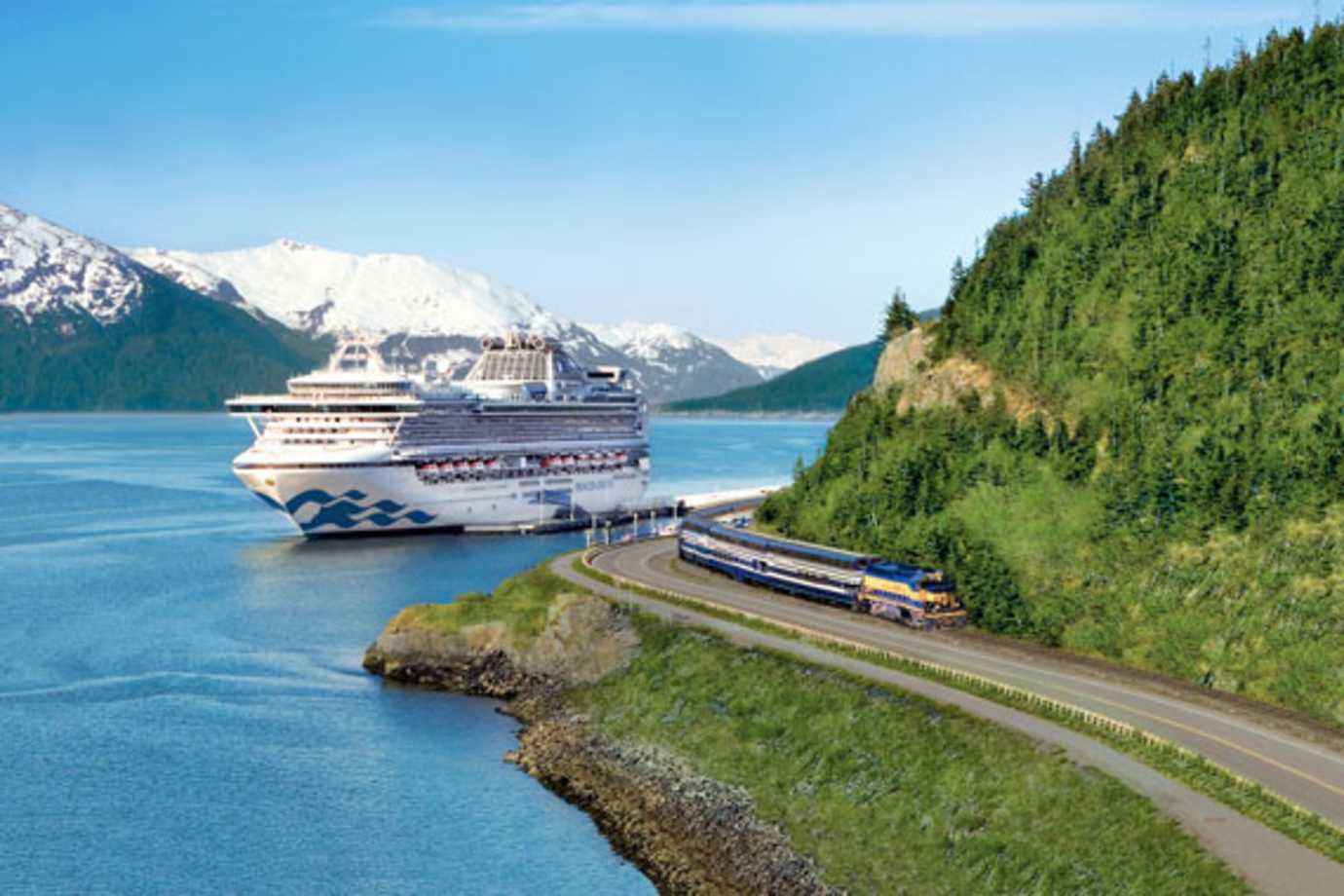 princess cruise ship at sea next to train on land