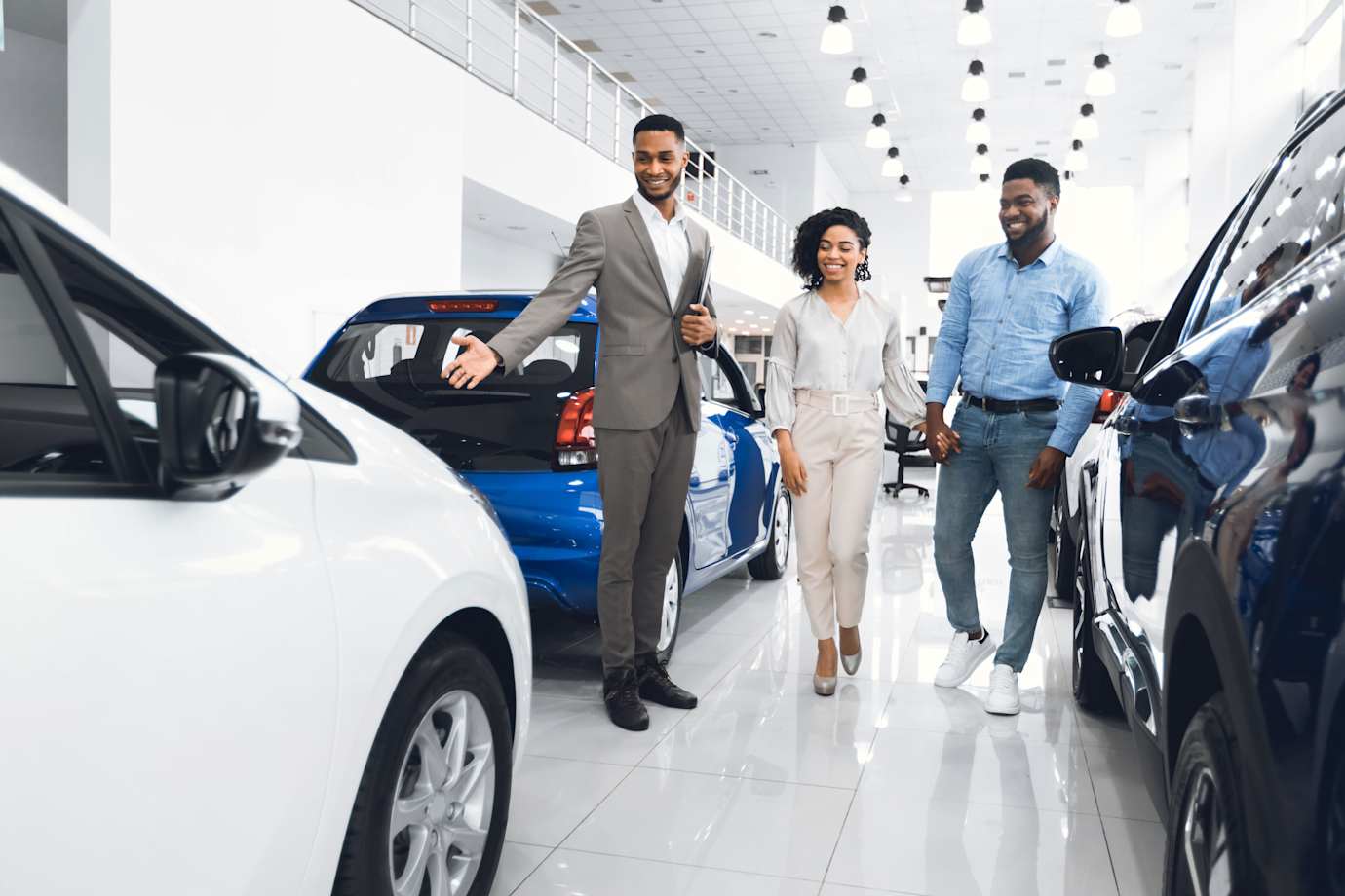 A couple look at a new car with a sales person.