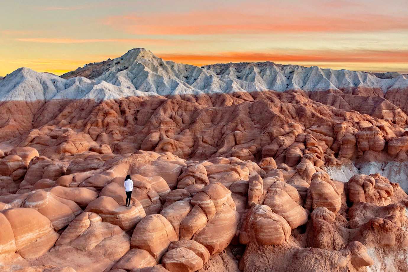 A woman stands on the badlands in Grand Staircase Escalante National Monument.