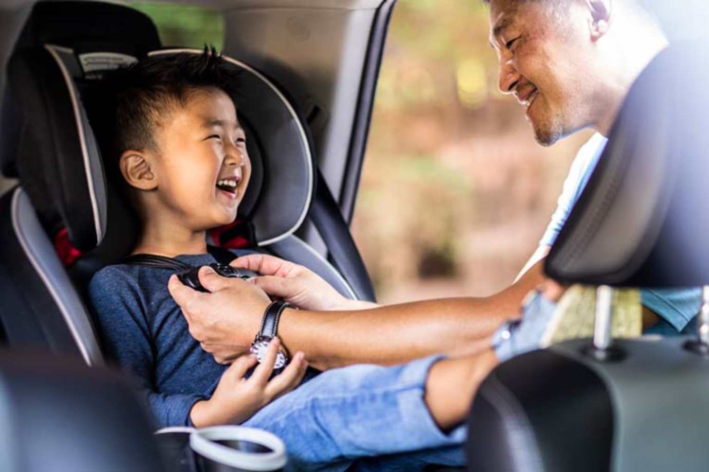 Dad putting child in car seat