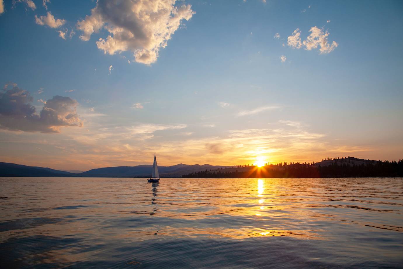 A boat sails at sunrise near Wildhorse Island on Flathead Lake near Kalispell, Montana.