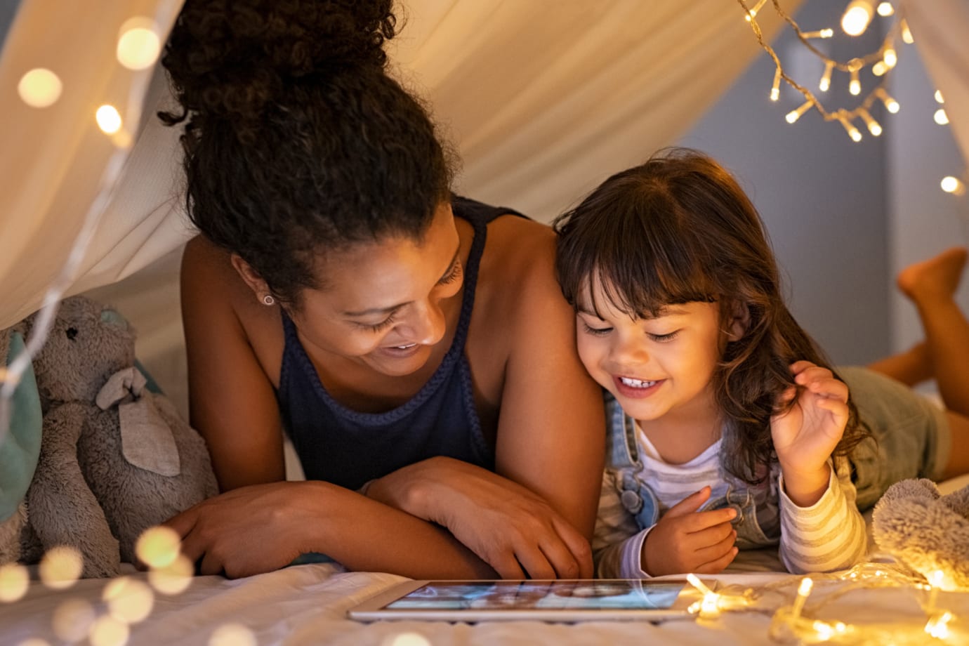 Mother and daughter playing a game under a tent
