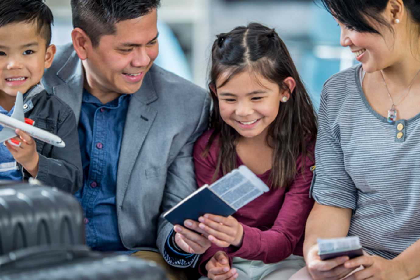 family at airport with passports and luggage