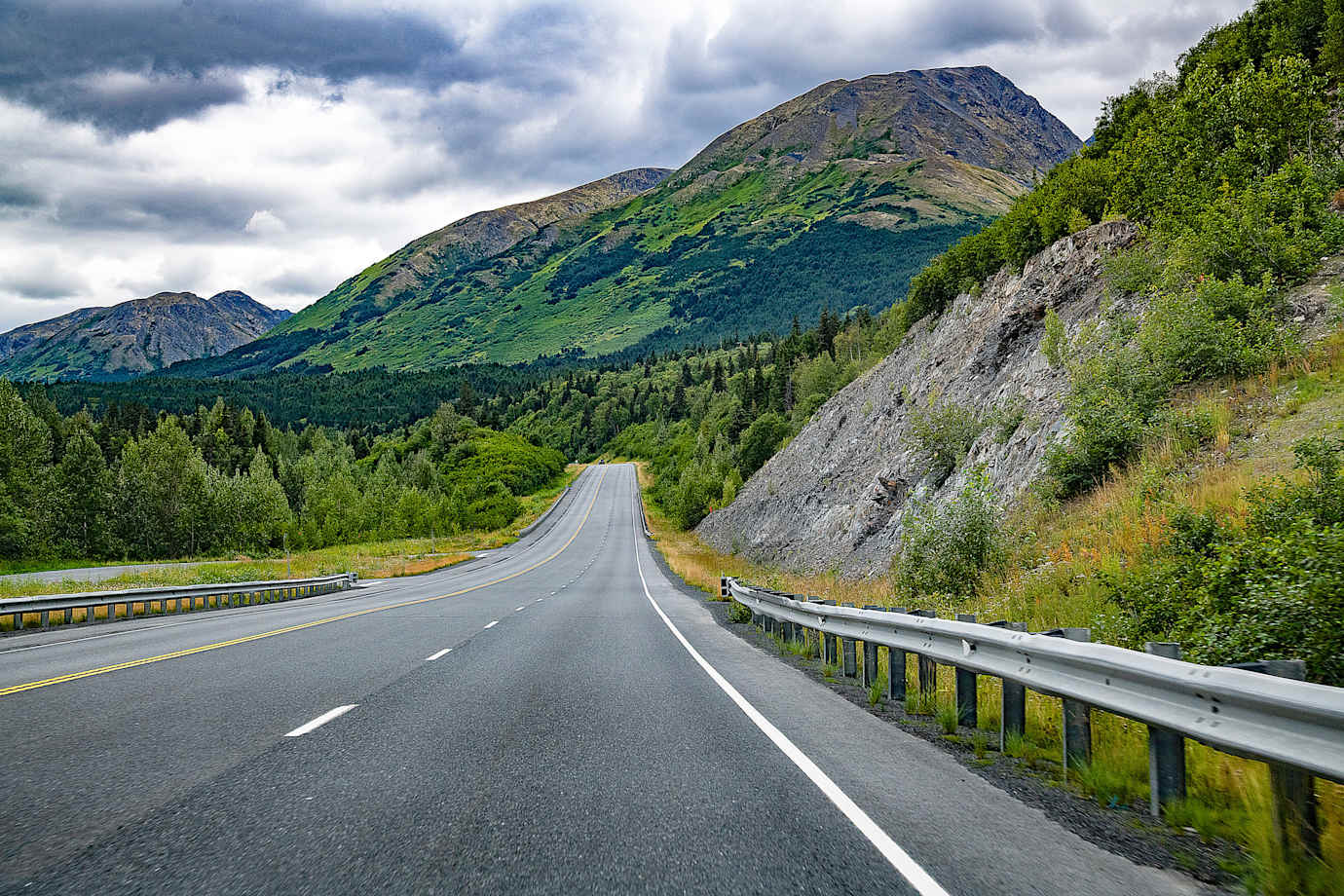 Landscape view of mountains and highway on Kenai peninsula on cloudy and rainy day.