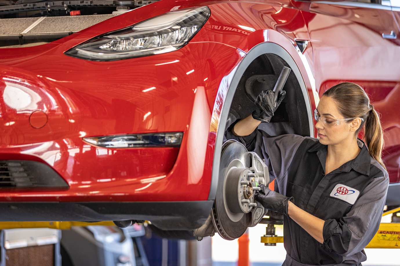 AAA auto repair technician inspecting breaks