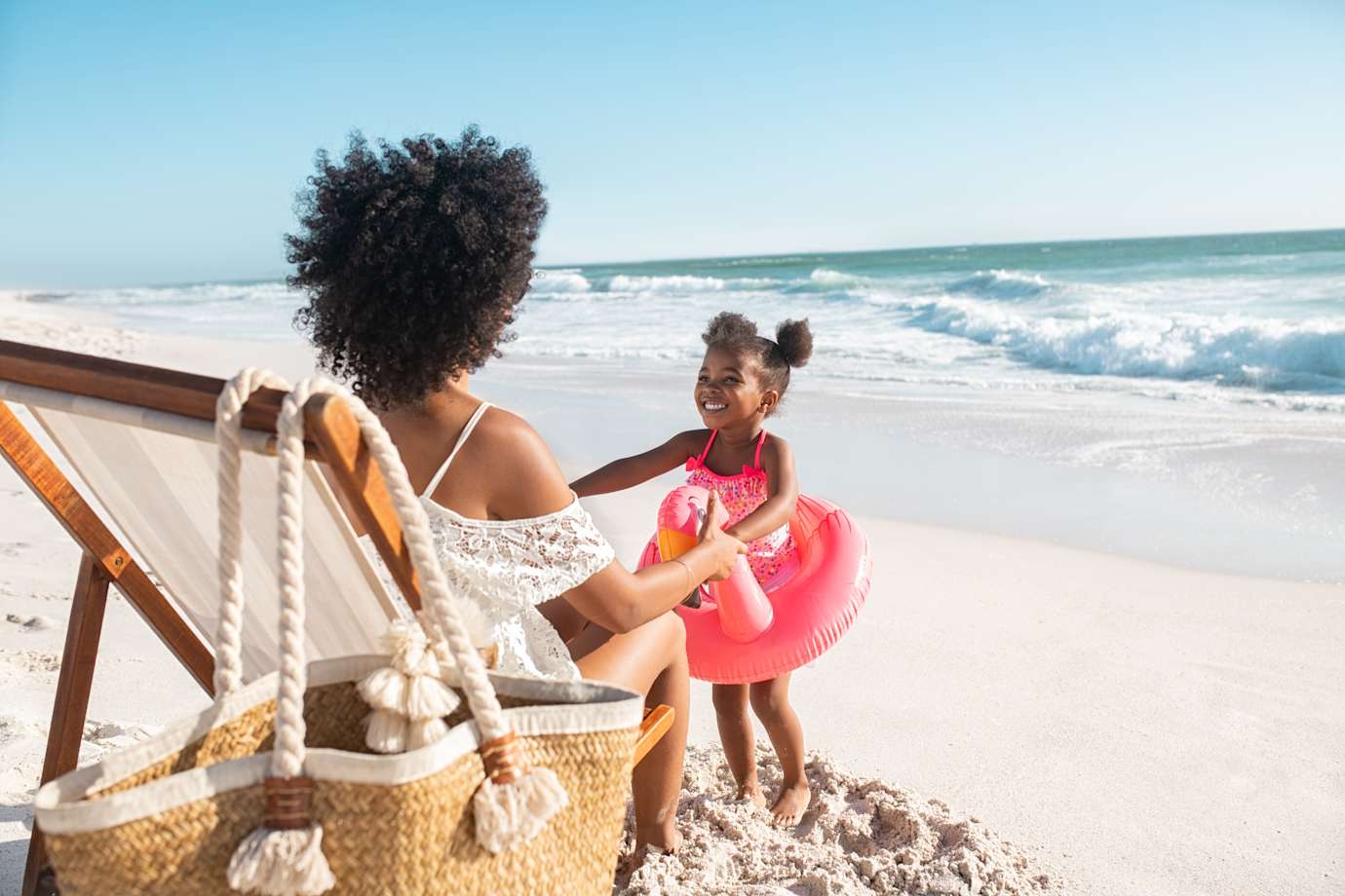 woman playing with daughter on beach