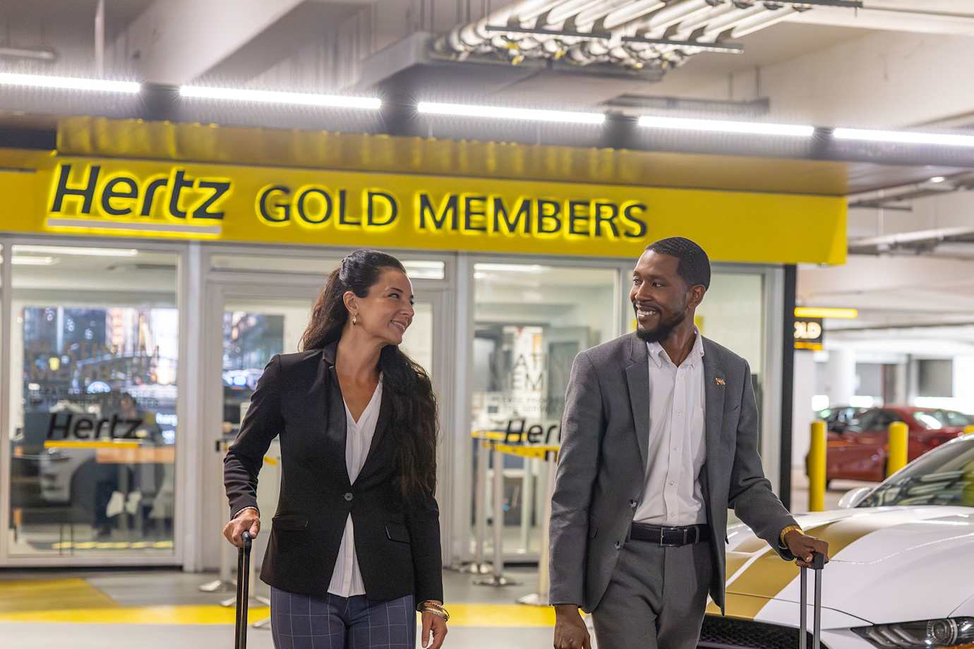 Couple with suitcases leaving Hertz Gold Members office