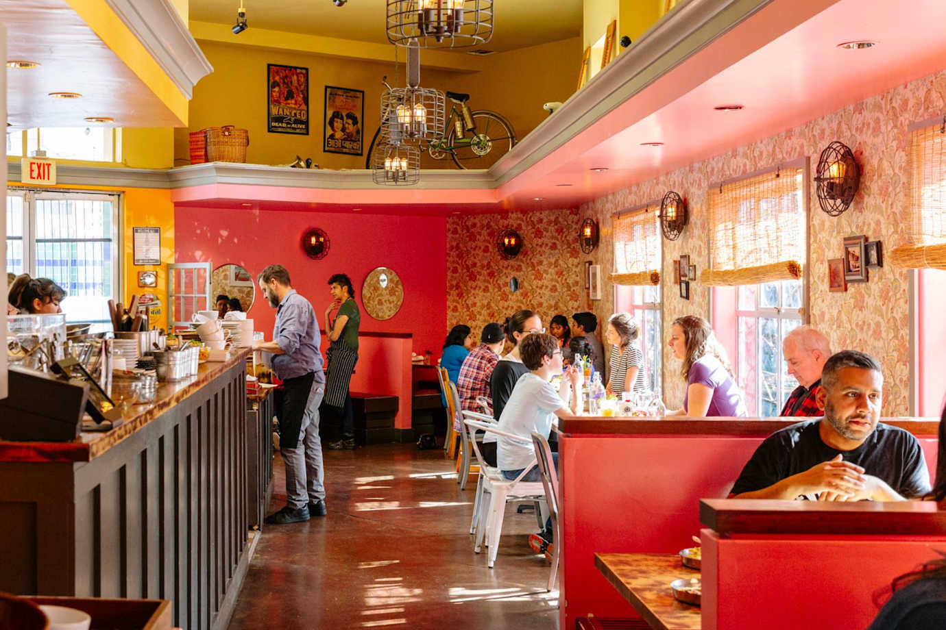 Spices and Southeast Asian prints line the walls of a lively, colorful restaurant. 