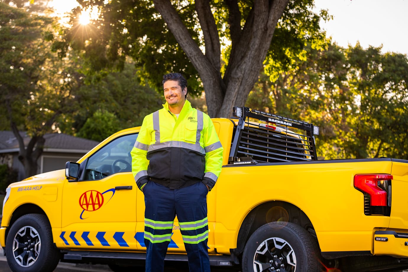 AAA roadside technician stands in front of his truck ready to help