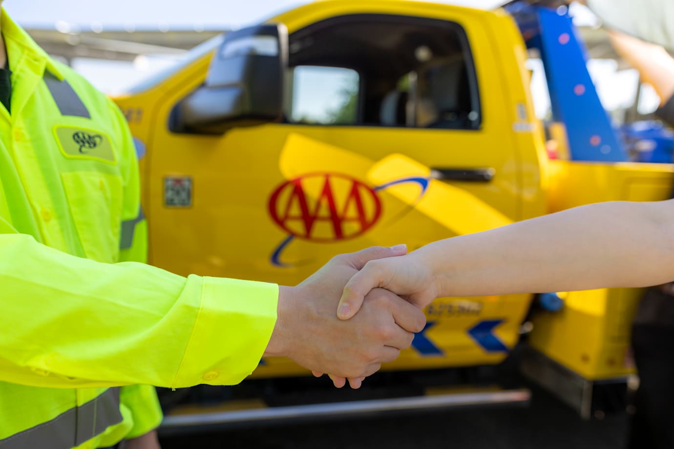 close up of AAA Member shaking hands with roadside technician