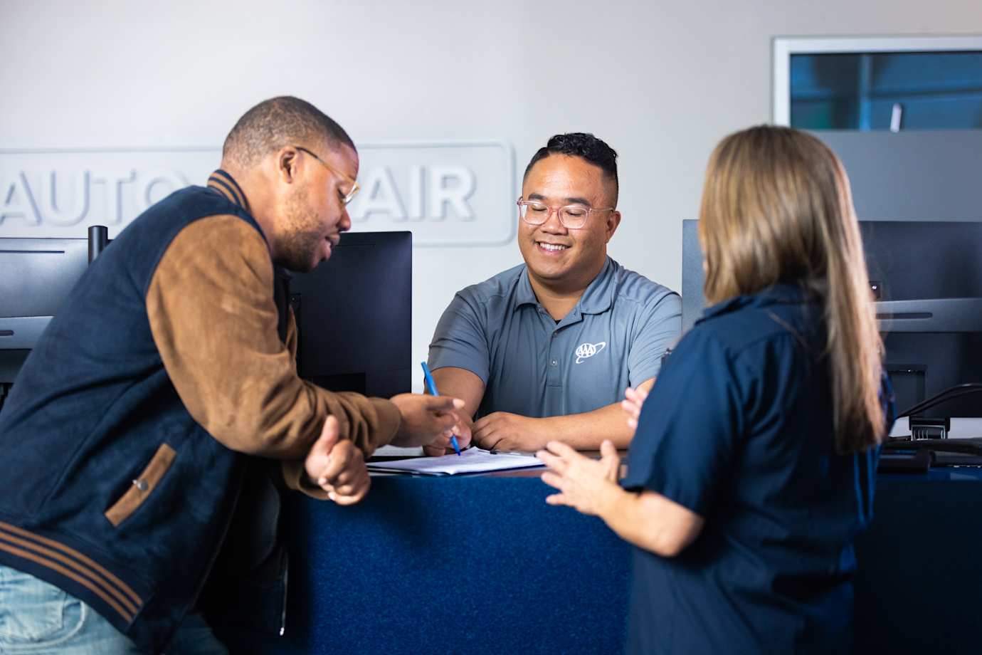 AAA auto repair center employee helps customers with auto repair financity