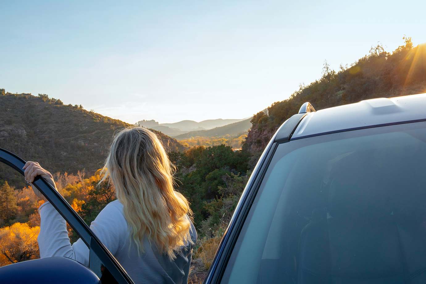 women standing by car door looking at mountains in the fall