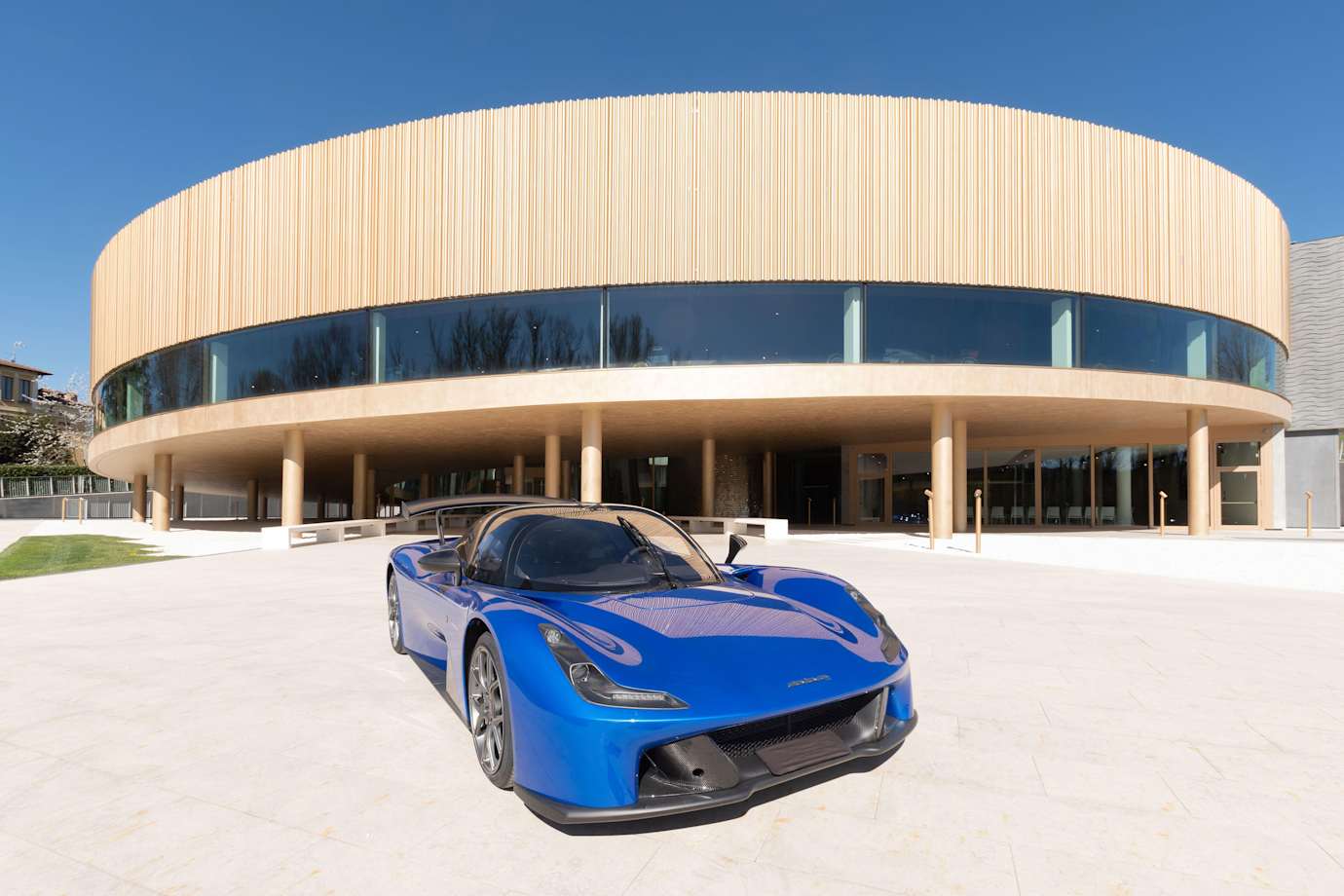 a blue Dallara Stradale sports car parked in front of the Dallara Academy