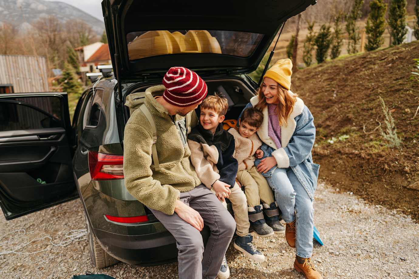 Family sitting in trunk of car