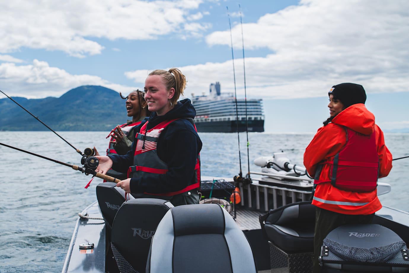 group fishing in small boat with holland america ship behind them