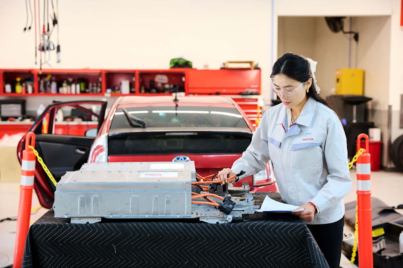 A mechanic prepares a new traction hybrid battery for a Toyota Prius