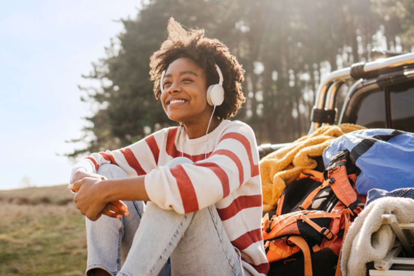 woman sitting on a truck bed listening to music