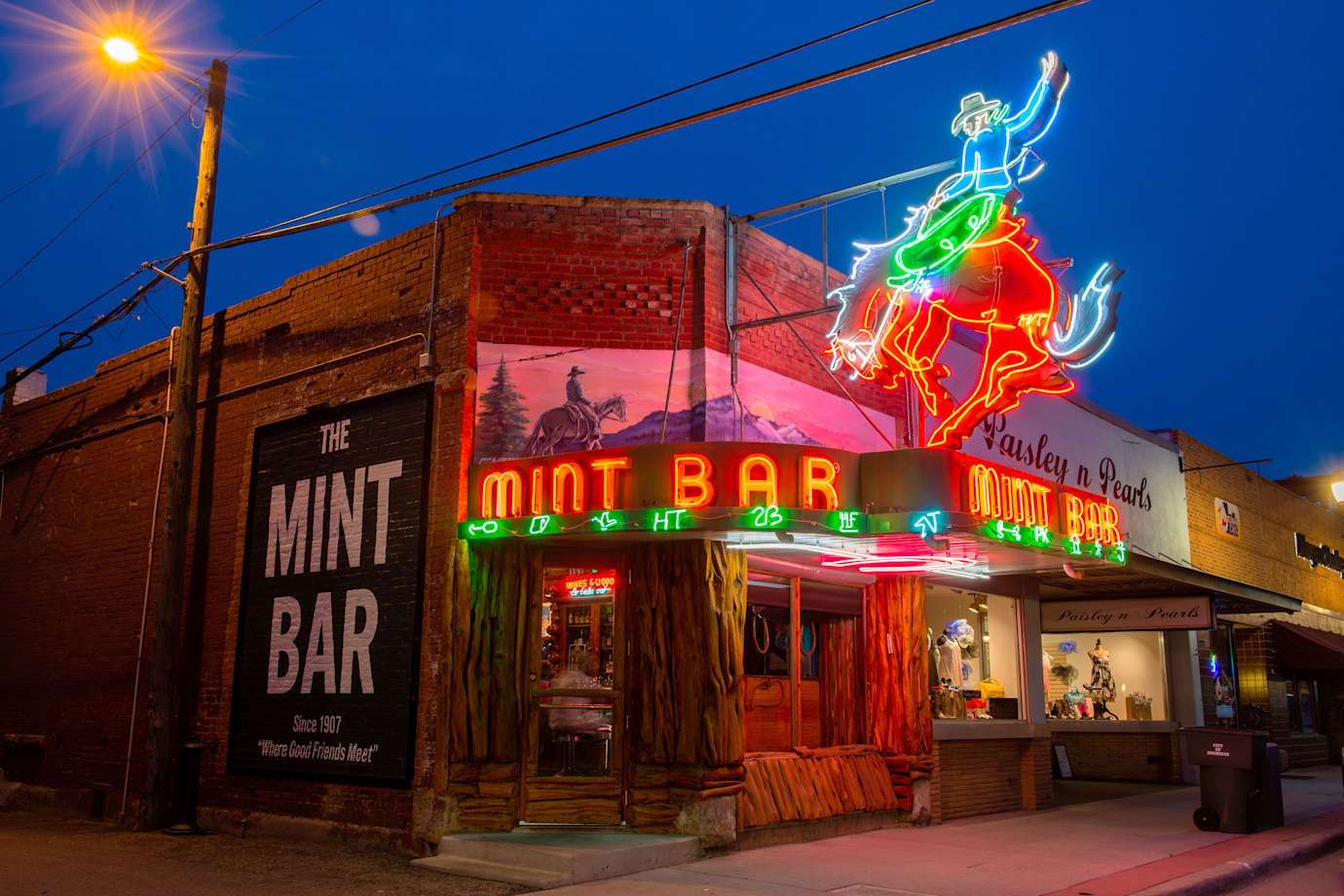 The neon glow of the Mint Bar’s giant bronco-busting cowboy lights up the street in Sheridan, Wyoming.