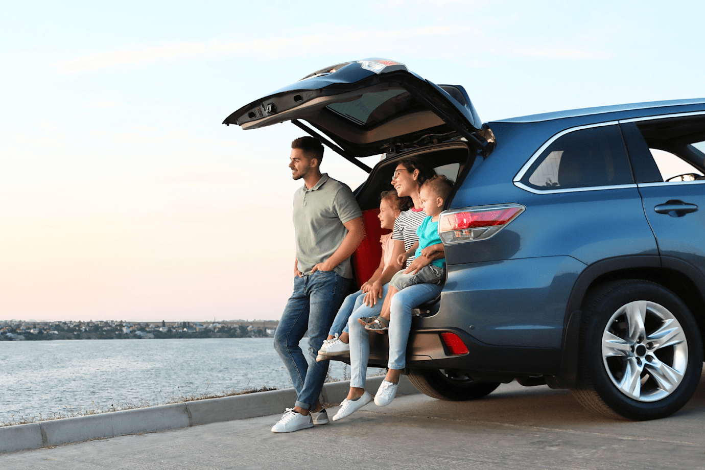 Man and woman sitting in trunk of SUV
