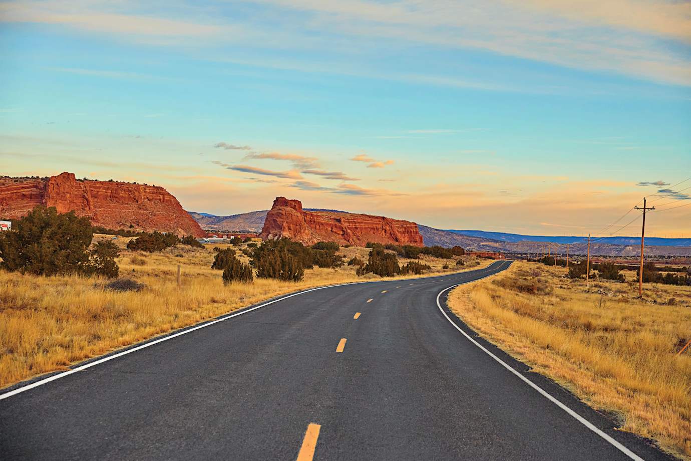 Route 66 fades off into the distance at dusk in New Mexico.