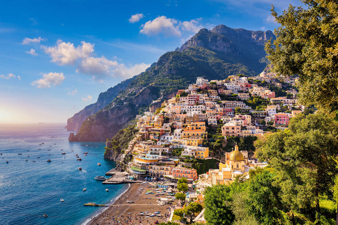 Colorful buildings hug the Amalfi Coast in Italy on a sunny day.