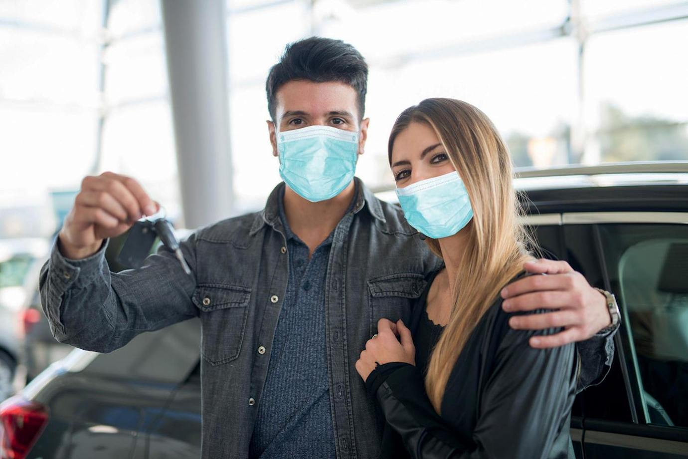AAA Members in face masks buy a new car in a dealership.