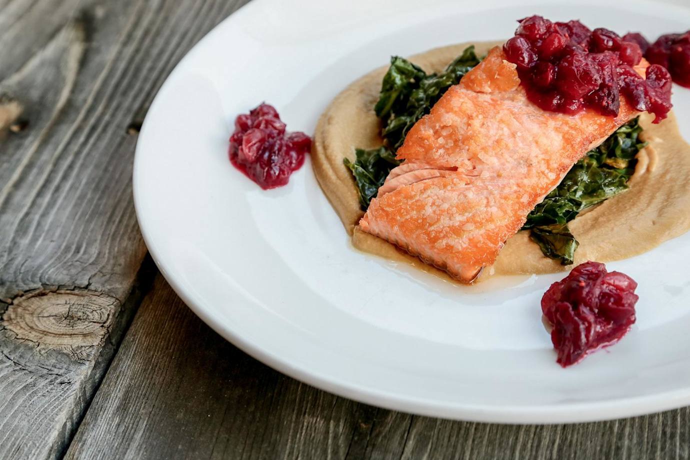 plate of pan-roasted salmon with cranberry compote, wilted greens on squash puree at Pueblo Harvest Cafe in the Pueblo Cultural Center, Albuquerque, New Mexico