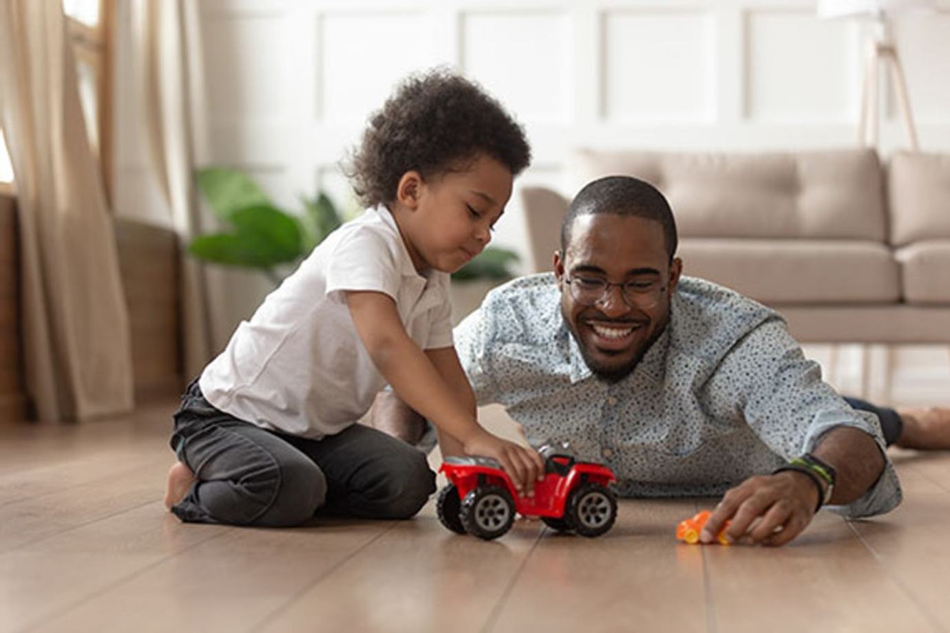 a AAA Member and his son play with a car on the floor