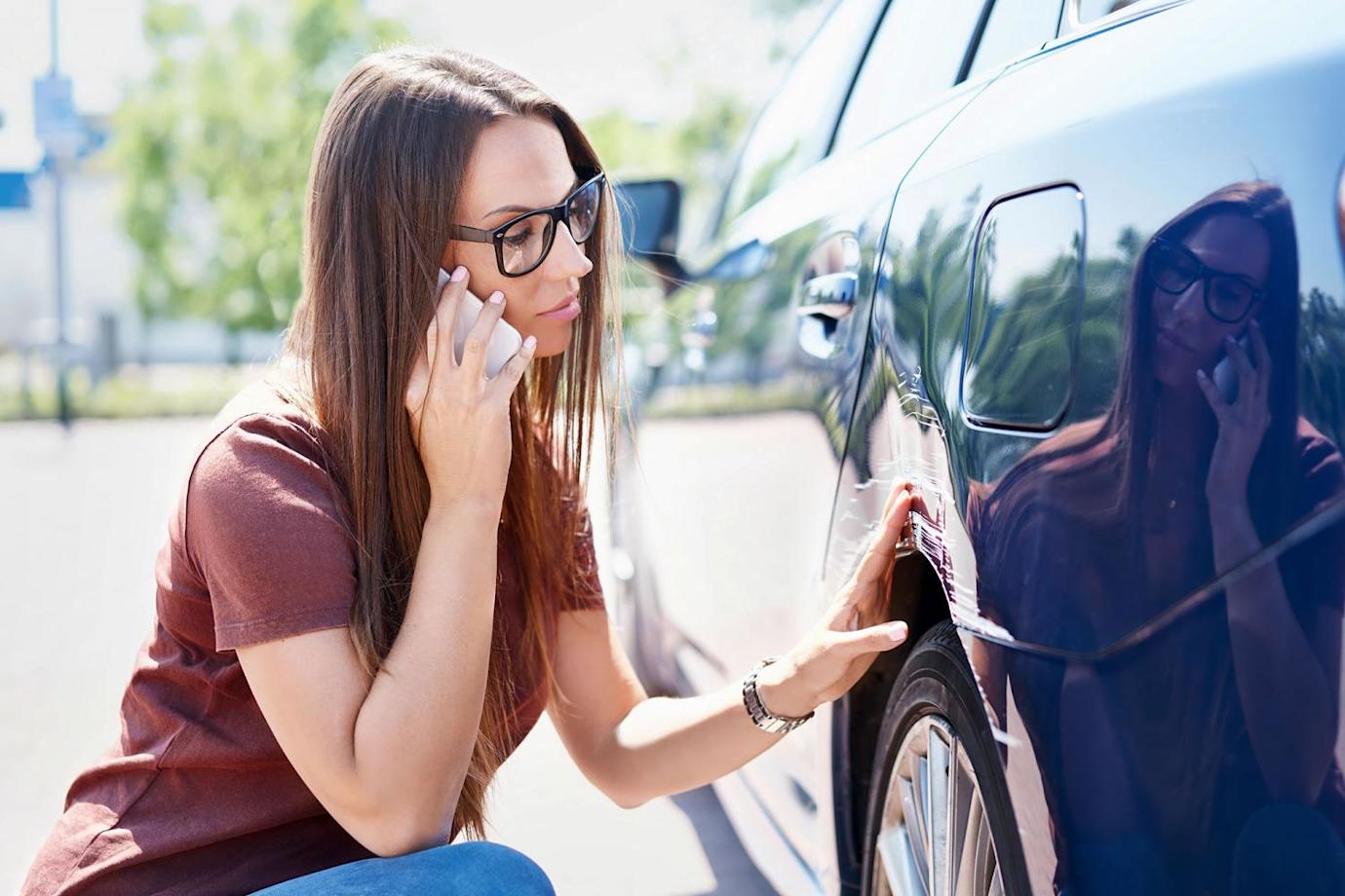A woman calls her insurance agent after her car was damaged in a hit-and-run crash.