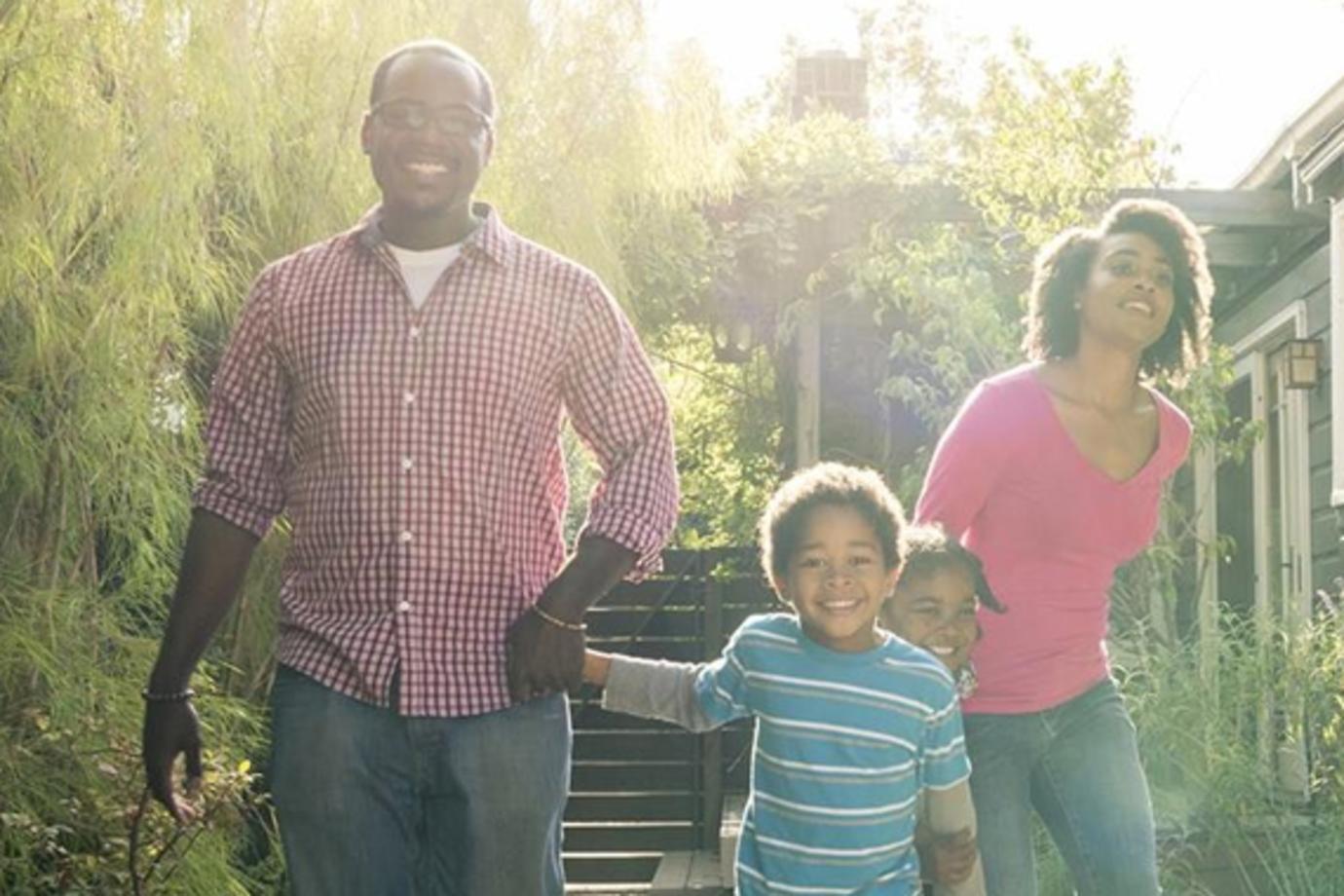 family holding hands outside of their home protected by AAA homeowners insurance