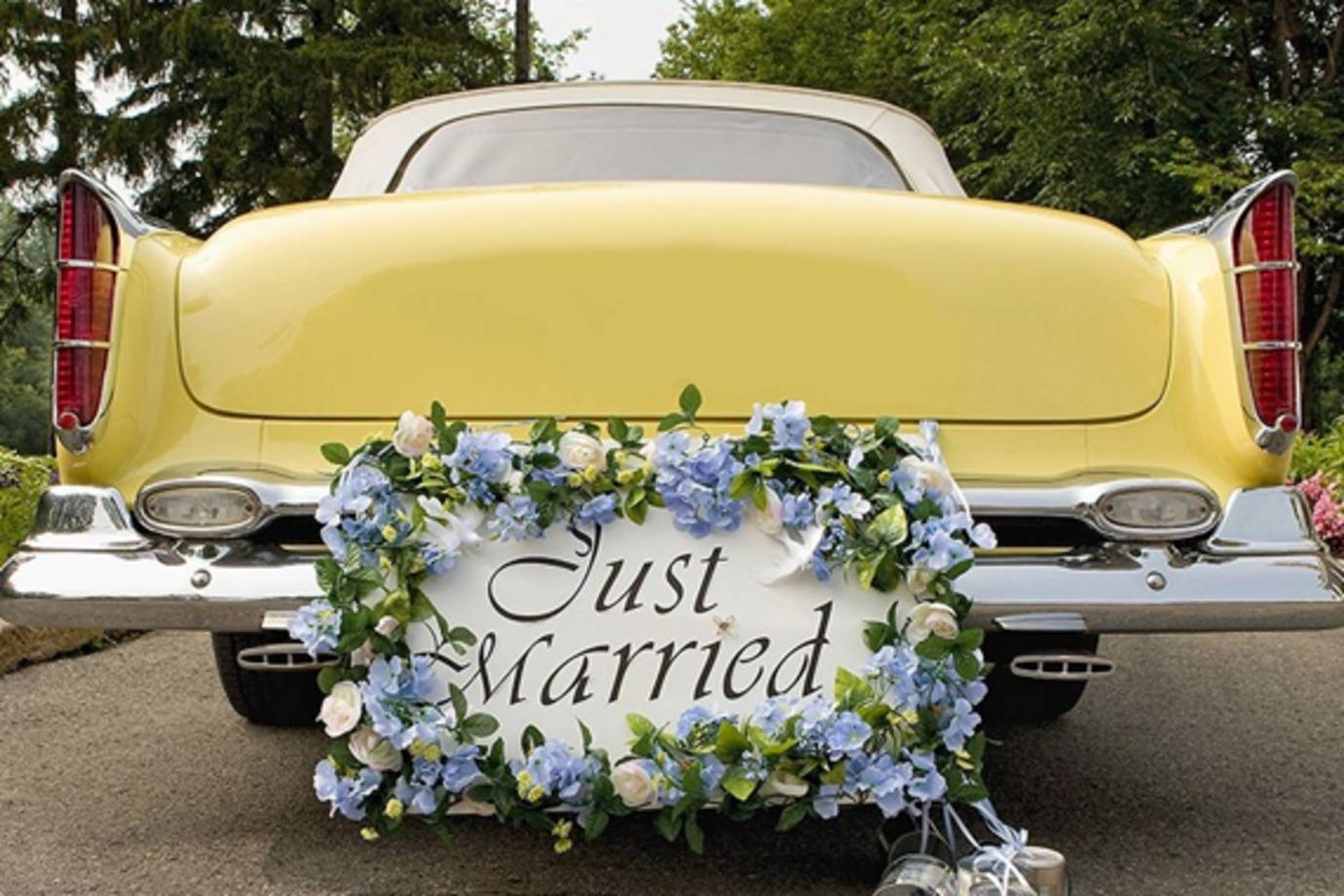 yellow antique car with a just married sign on the back bumper