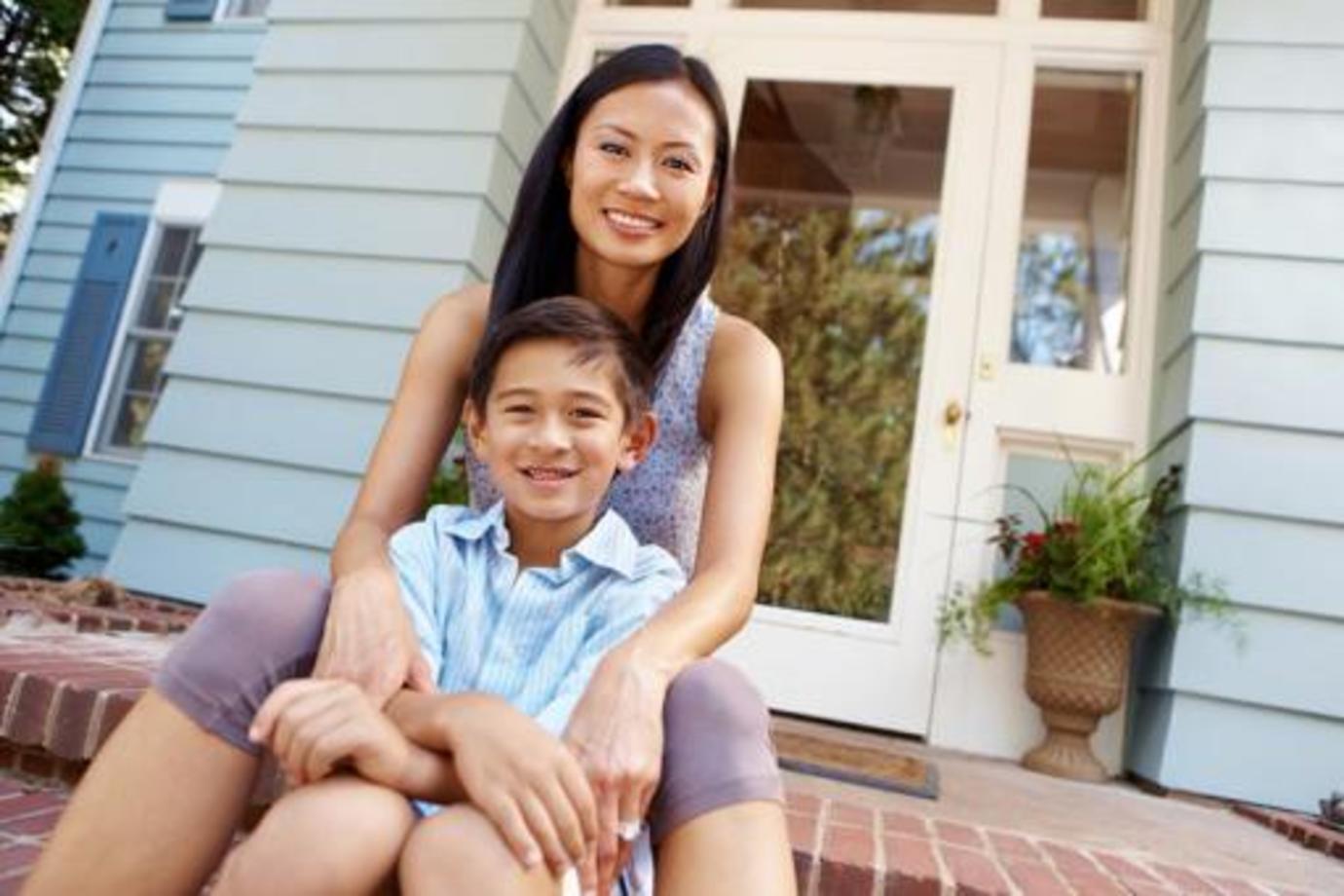 a mother and sun sit on the porch of their rented unit