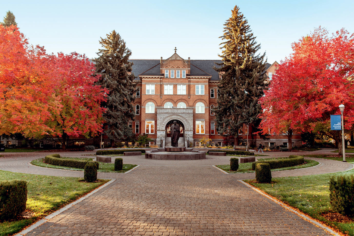 College Hall at Gonzaga University in Spokane, Washington surrounded by trees with red leaves.