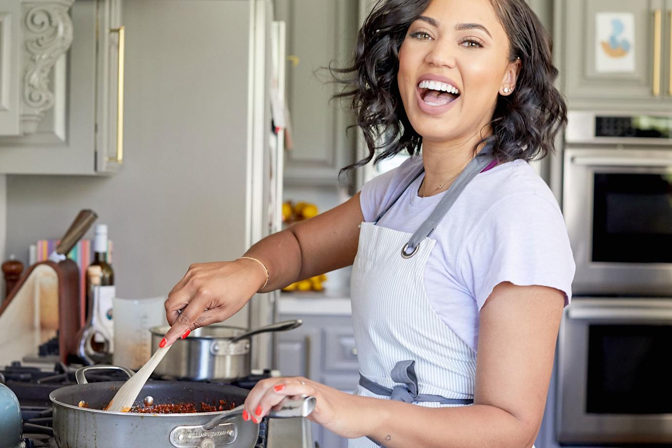 Ayesha Curry cooking in her home kitchen.